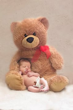 a baby sleeps next to a teddy bear