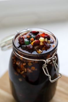 a jar filled with fruit and nuts sitting on top of a wooden cutting board