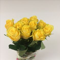 a vase filled with yellow roses on top of a table