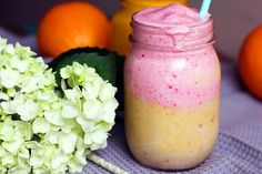 there is a drink in a mason jar next to some oranges and other fruit