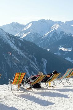 several lawn chairs sitting on top of a snow covered slope