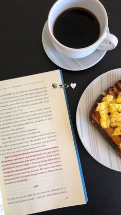 an open book next to a cup of coffee and a plate with food on it