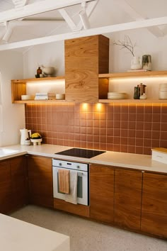 a kitchen with wooden cabinets and tile backsplash, white counter tops, and an oven