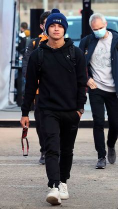 a man walking down the street wearing a face mask