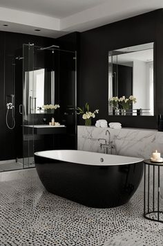 a black and white bathroom with a claw foot bathtub in the middle of it