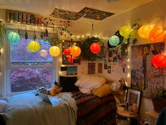 a bedroom with lights hanging from the ceiling and pictures on the wall above it, along with other decorations