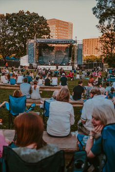 an outdoor concert with people sitting in lawn chairs