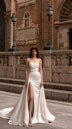 a woman in a white dress standing on the street