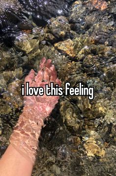 someone is holding their hand out in the water with words that read i love this feeling