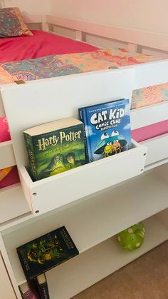 books are sitting on top of the book shelf in this child's bed room