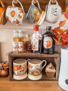 there are many cups and mugs on the shelf in the kitchen with autumn leaves