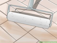 a mop is sitting on the floor in front of a tile wall with white grout