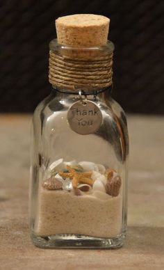 a glass bottle filled with sand and shells