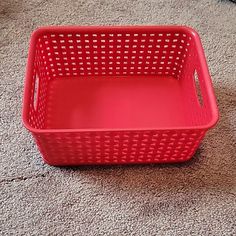 a red plastic basket on the floor