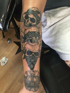 a person with a tattoo on their arm holding a cell phone in one hand and a skull in the other