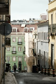 a man walking down an alley way between two buildings