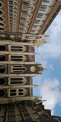 the view from below looking up at an ornate building with clocks on it's sides