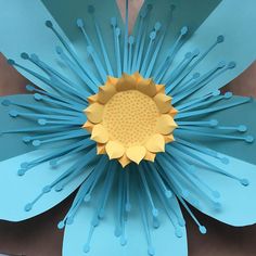 a paper flower with blue and yellow petals on it's center, surrounded by straws