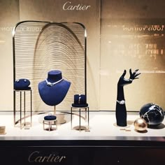 an assortment of jewelry displayed on display in a store window with the caption cartier