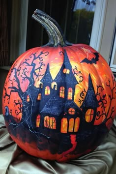 a painted pumpkin with a house on it