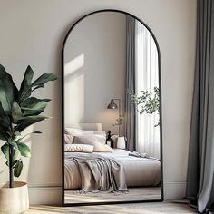 a large mirror in the corner of a room next to a potted plant and bed