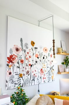 a living room with flowers painted on the wall and plants in vases next to it