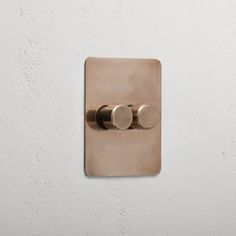 a light switch with two knobs on the wall