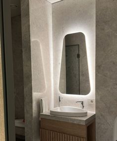 a bathroom with a sink, mirror and urinal next to a wall mounted toilet