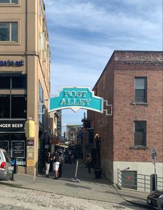 people are walking under the foot alley sign