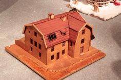 a wooden model of a house sitting on top of a table