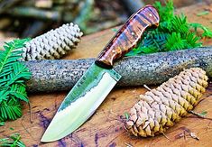 a knife and some pine cones on a table