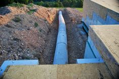 a pipe laying in the ground next to a building