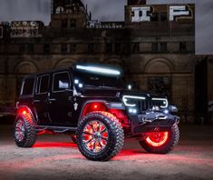 a black jeep with orange wheels and lights