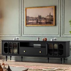 a living room with a large painting on the wall next to a black entertainment center