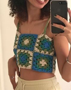 a woman with curly hair wearing a crocheted crop top