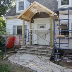 a house being built with scaffolding around the front door and steps leading up to it