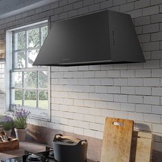 a stove top oven sitting on top of a kitchen counter next to a window with potted plants