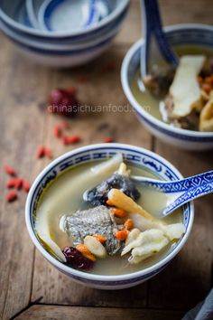 two bowls filled with soup on top of a wooden table