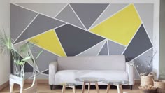 a living room filled with furniture and a wall painted in grey, yellow and white