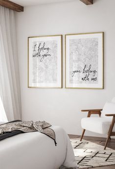 two framed pictures hang on the wall above a bed in a room with white walls