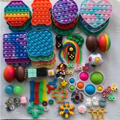 there are lots of toys and beads on the white table top, including bracelets