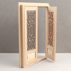 an open wooden door with intricate carvings on the front and side panels, in white wood