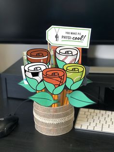 a bouquet of flowers sitting on top of a desk next to a keyboard