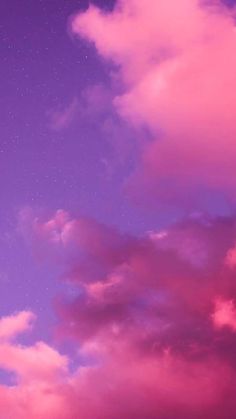 the sky is filled with pink clouds and stars