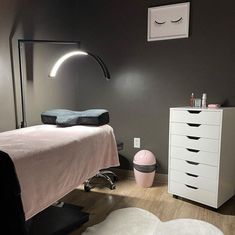 a white bed sitting next to a dresser in a bedroom on top of a hard wood floor