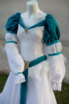 a white and blue dress with ruffled sleeves on a mannequin headdress