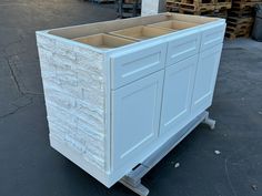 a white cabinet sitting on top of a pallet