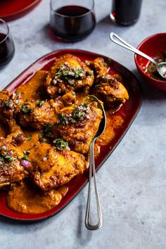 a red plate topped with meat covered in sauce