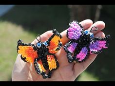 two small crocheted butterflies sitting on top of each other in someone's hand