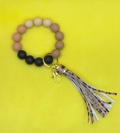 the beaded bracelet with leopard print tassel is shown on a yellow background